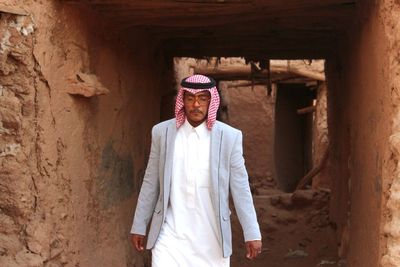 Full length of man standing against wall in building