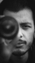 Close-up portrait of young man looking through object