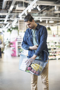 Man carrying grocery basket in organic supermarket