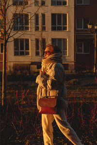 Young woman standing against building