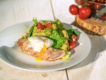 Close-up of salad with poached egg served in plate on table