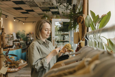 Blond customer reading label on organic loofah in store