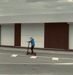 Full length of man riding bicycle on road