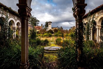 Facade of old building against cloudy sky