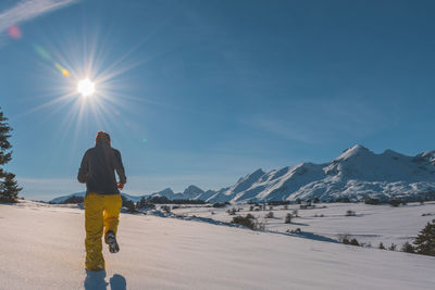 An unrecognizable young caucasian woman running towards the french alps mountains