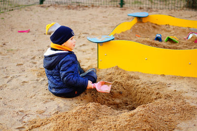 Boy playing with toy on sand