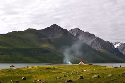 Scenic view of mountains and lake against cloudy sky