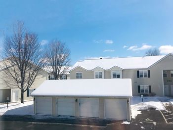 Snow covered houses and buildings against sky