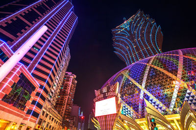 Low angle view of illuminated buildings against sky at night