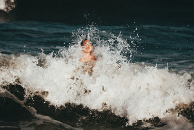 Portrait of shirtless man swimming in sea