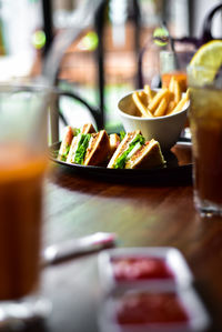 Sandwich with french fries in plate on wooden table