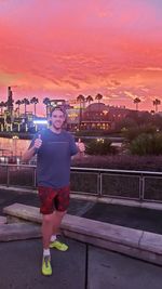 Portrait of smiling man standing against sky during sunset