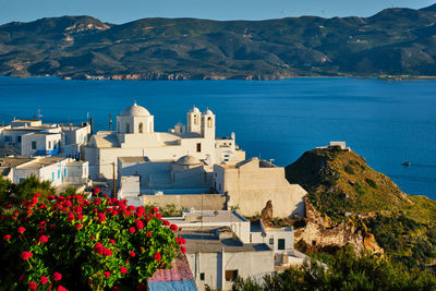 Scenic view of sea by buildings against mountains