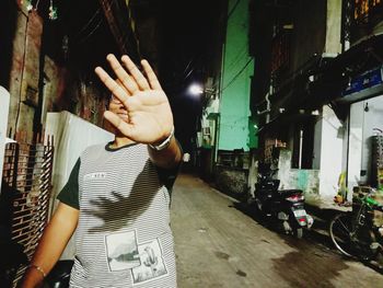 Midsection of woman standing on illuminated street at night