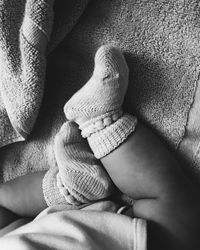 Low section of baby boy on bed at home