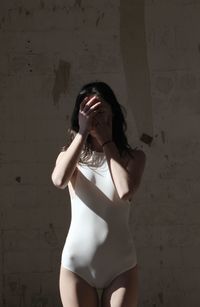 Young woman standing against wall