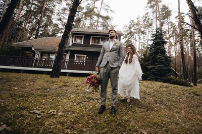 Couple with bouquet standing in forest