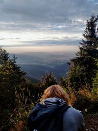 Rear view of woman looking at mountain against sky