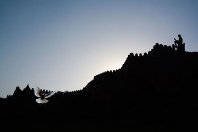 Low angle view of silhouette mountain against clear sky