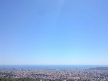 Aerial view of cityscape against clear blue sky