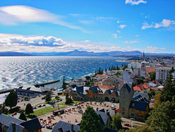 High angle view of townscape by sea against sky