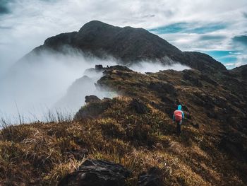 Rear view of person on mountain against sky