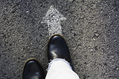 Low section of person standing on road