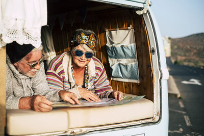 Couple looking at map while lying in motor home