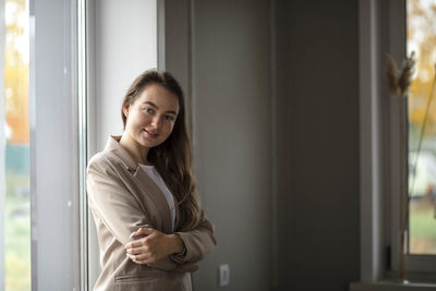 A smiling businesswoman. a small business entrepreneur stands near the window in her office