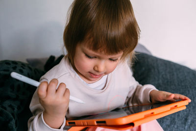 Child using technology. toddler at home with a tablet and a pen stylus and draws