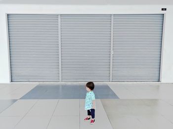 Side view of boy standing on floor