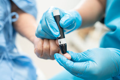 Midsection of doctor holding dental equipment