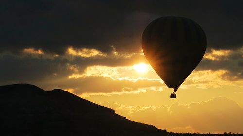 Silhouette hot air balloon flying over cappadocia during sunrise