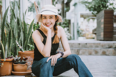 Portrait of smiling young woman sitting outdoors