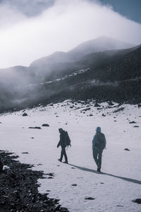 People walking on snow covered land during winter