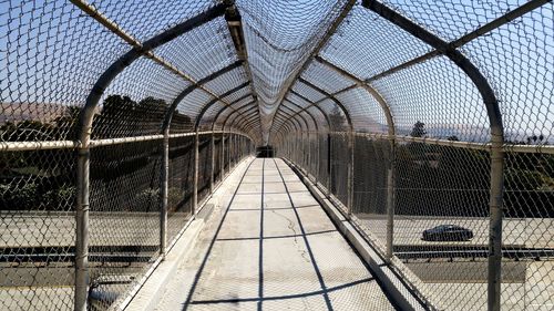 Footbridge in city against sky