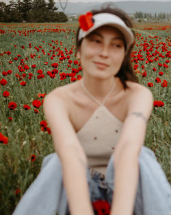 Portrait of young woman sitting on field