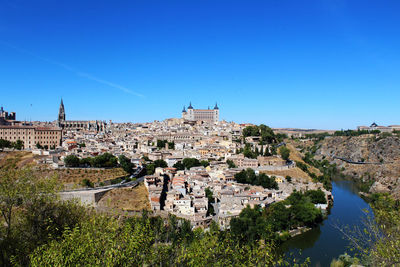 Buildings in town against clear blue sky
