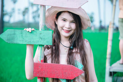 Portrait of smiling young woman holding hat