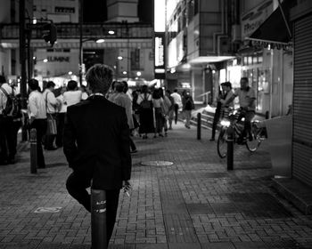 People walking on illuminated street at night