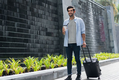 Young man standing against wall