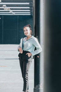 Full length of young woman standing in city