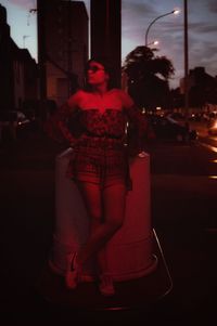 Midsection of woman on illuminated street at night