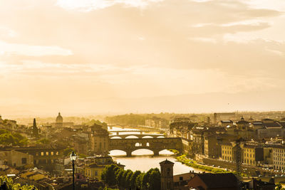 Arno river amidst cityscape against sky