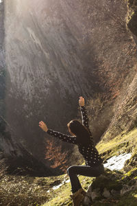 High angle view of woman sitting on rocky mountains