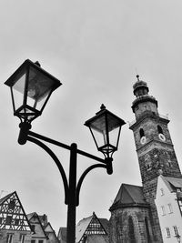 Low angle view of street light by building against sky