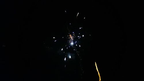 Firework display against sky at night