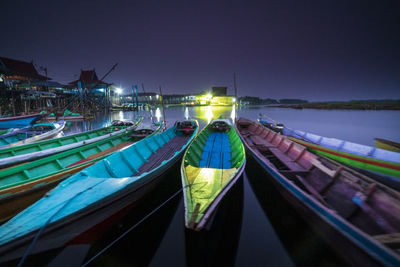 Panoramic view of illuminated boats moored in sea against clear sky
