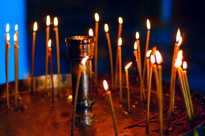 Lighting candles in the church . praying with burning candles