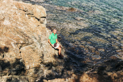 High angle view of man surfing on rock